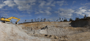 Retro excavadora arrancando el material siliceo para la produccion